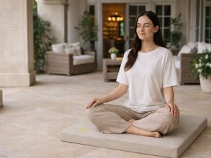 Woman sitting on the best zabuton for meditation on hard floors on a luxurious patio